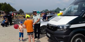 Inspektor promuje bezpieczeństwo w ruchu drogowym rozdając elementy odblaskowe.