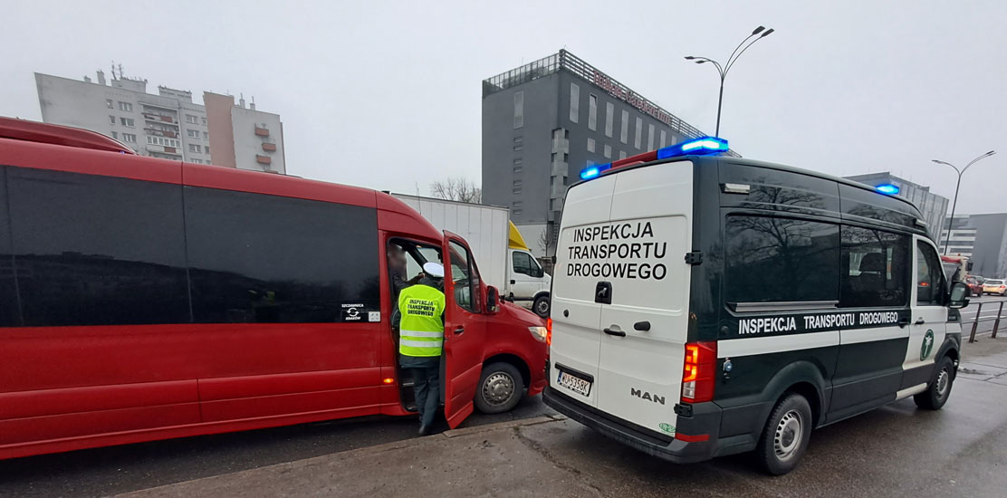 Inspektor podczas kontroli autobusu realizującego regularny przewóz osób.