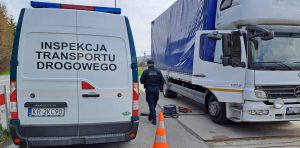 Inspektor dokonuje pomiarów dymomierzem podczas akcji weryfikacji spełniania dopuszczalnych norm emisji spalin. W tle kontrolowany pojazd.